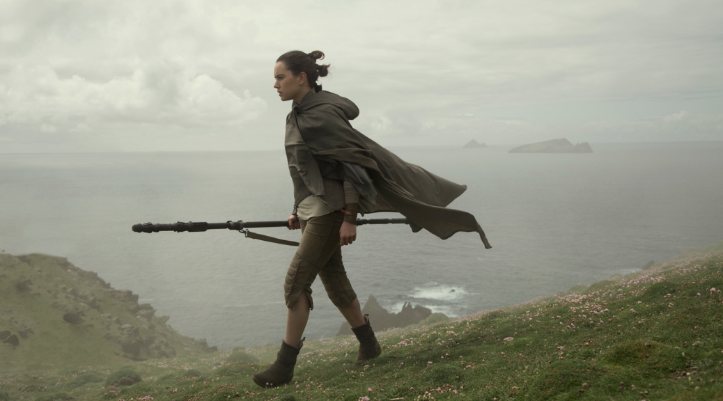 Rey walking with staff on island