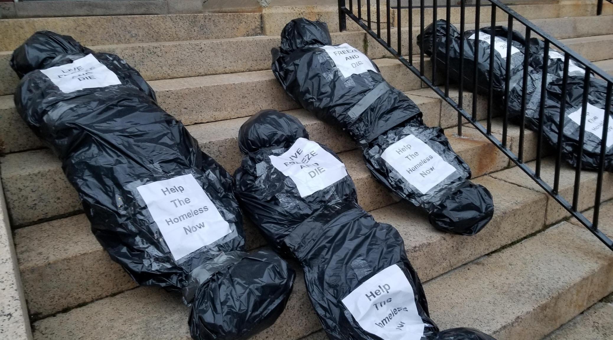 Protesters in Dover lay five body bags representing the neglected homeless....